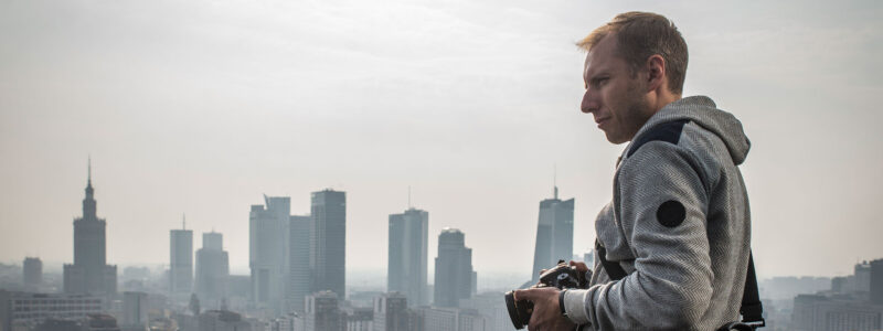 Fotograf ogląda panoramę miasta z dachu wieżowca